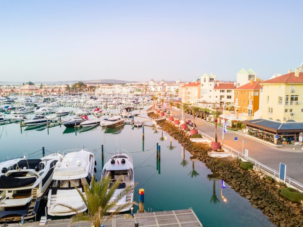 Luxury marina with yachts and waterfront apartments in a scenic coastal town. Marina with yachts and waterfront apartments in a scenic coastal town.